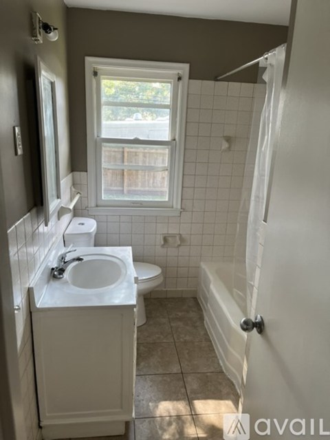 A bathroom with a toilet, sink, and bathtub.