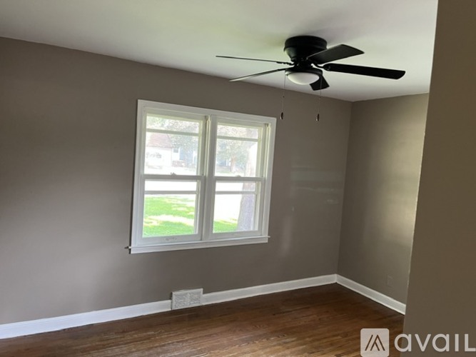 A room with a ceiling fan and a window.