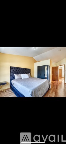 A bedroom with a large bed and a wooden floor.