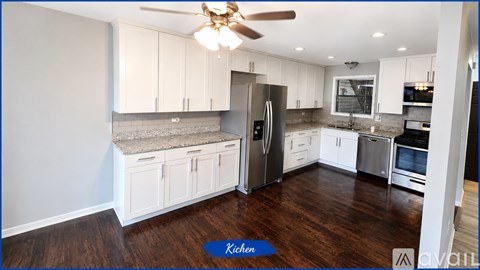 A kitchen with white cabinets and a refrigerator.