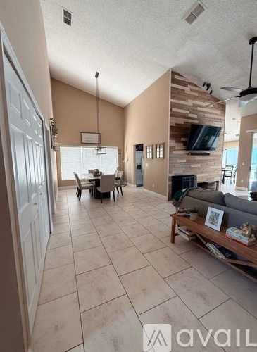 A living room with a couch, a coffee table, and a TV.