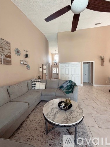 A living room with a grey couch and a marble coffee table.
