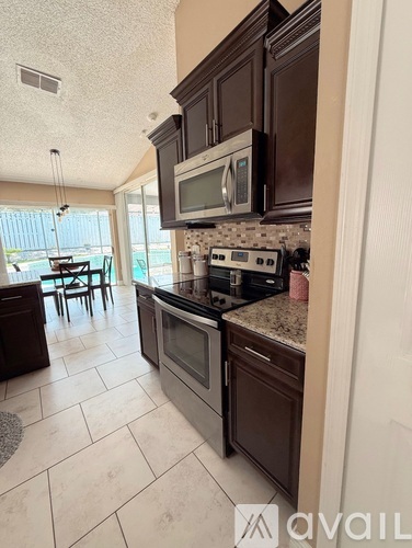 A kitchen with brown cabinets and a black stove top oven.