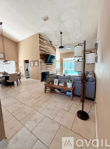 A living room with a couch, a table, and a ceiling fan.