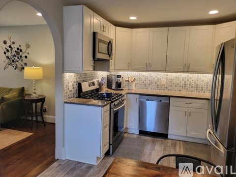 A kitchen with white cabinets and a tiled backsplash.