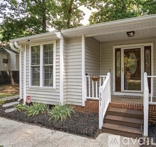 A small house with a front porch and a small garden.