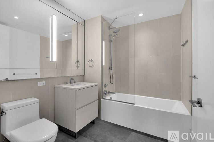 A modern bathroom with a toilet, sink, and bathtub.