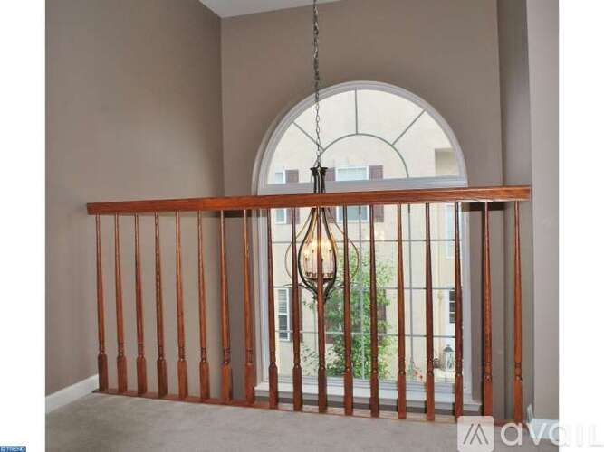 A balcony with a metal railing and a hanging light fixture.