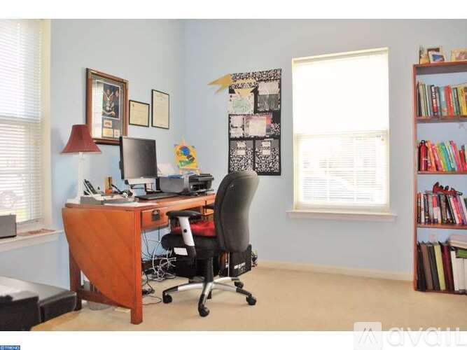 A room with a desk, chair, and bookshelf.