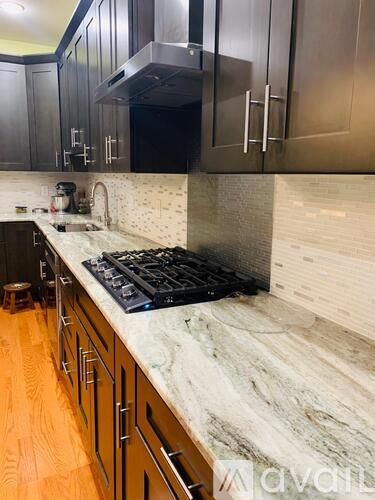 A kitchen with a marble countertop and stainless steel appliances.