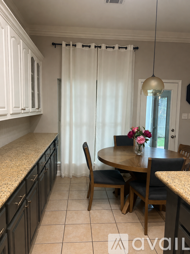 A kitchen with a table and chairs in the middle.