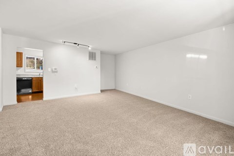 A large, empty room with carpeted flooring and white walls.