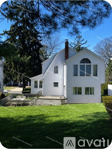 A white house with a black fence in front of it.