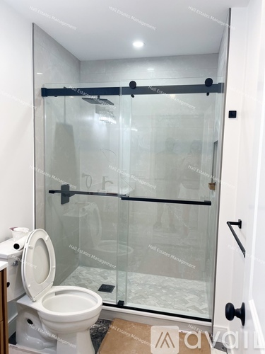 A white toilet sits next to a walk-in shower with a glass door.