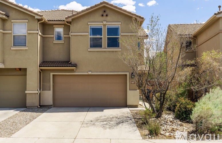 A beige house with a brown garage door.