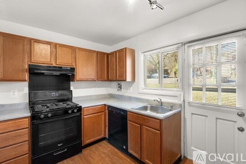 A kitchen with wooden cabinets and a black stove top oven.
