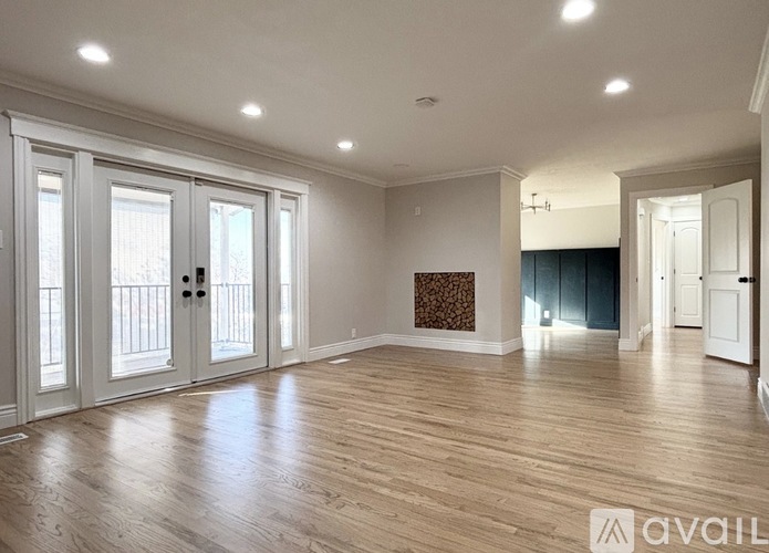 A spacious room with wooden floors and white walls.