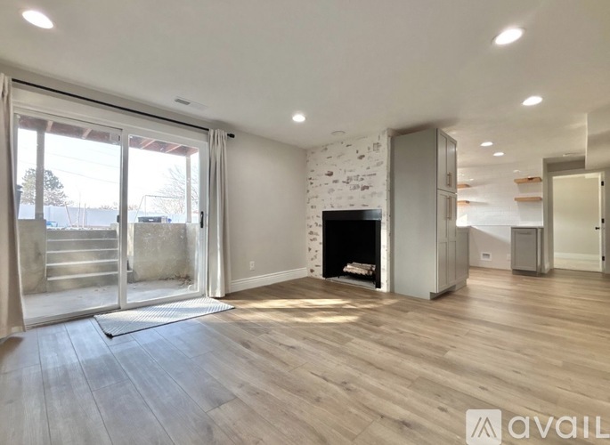 A spacious living room with a fireplace and wooden flooring.