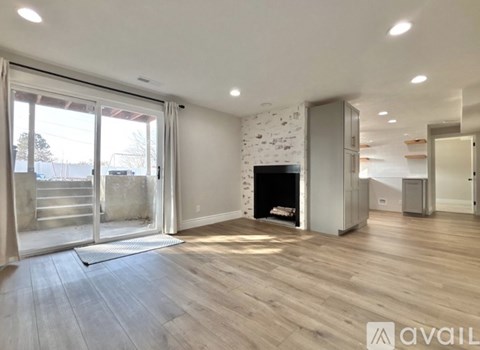 A spacious living room with a fireplace and wooden flooring.