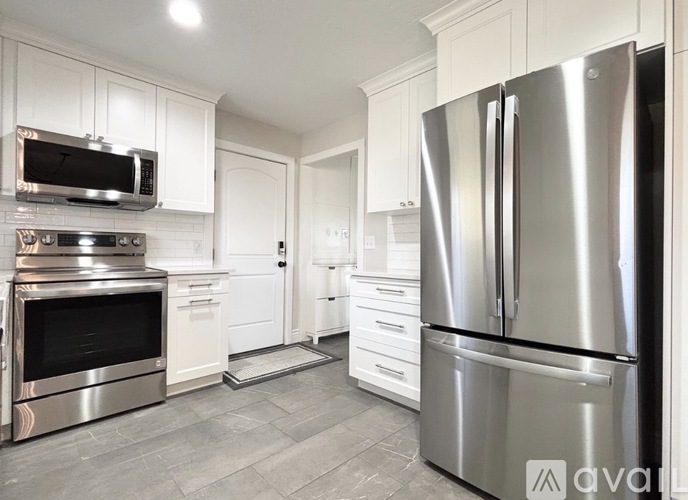 A modern kitchen with a stainless steel refrigerator and oven.