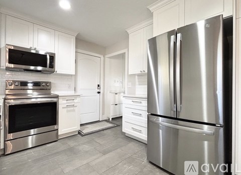 A modern kitchen with a stainless steel refrigerator and oven.