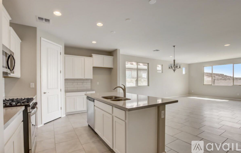 A modern kitchen with a large island and a view of the outdoors.