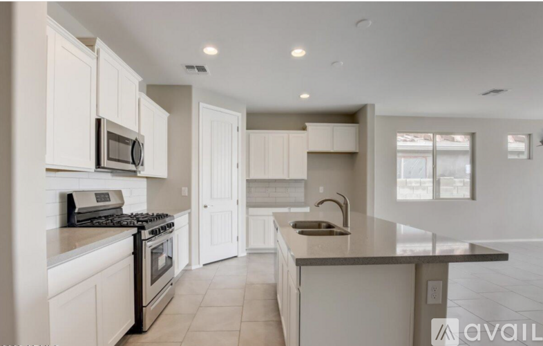 A modern kitchen with white cabinets and appliances.