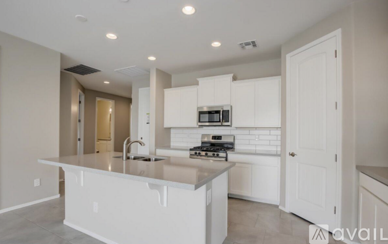 A modern kitchen with white cabinets and appliances.