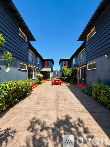 A row of houses with a red bench in the middle of the walkway.