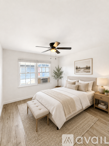 A bedroom with a bed, bench, and a ceiling fan.
