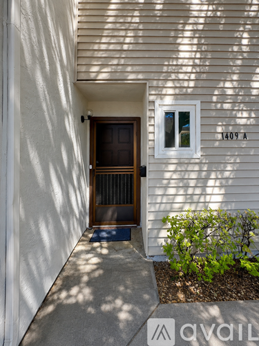 A white house with a brown door and a window with the number 1409 on it.