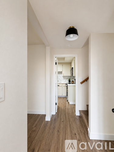 A hallway with a light on the ceiling and a door on the right.