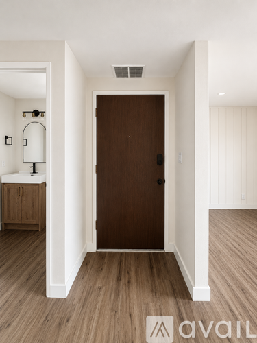 A room with a brown door and wooden flooring.