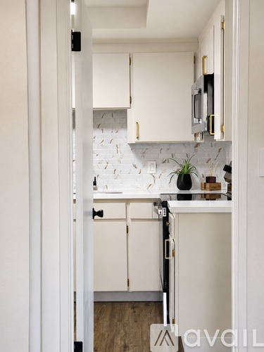 A kitchen with white cabinets and a white backsplash.