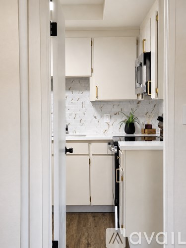 A kitchen with white cabinets and a white backsplash.