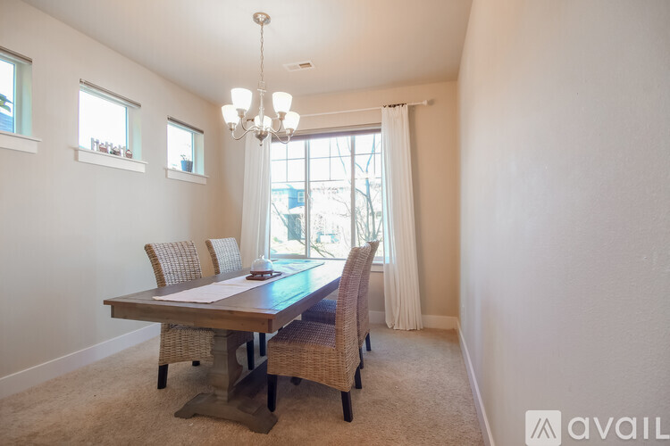A dining room with a wooden table and chairs.