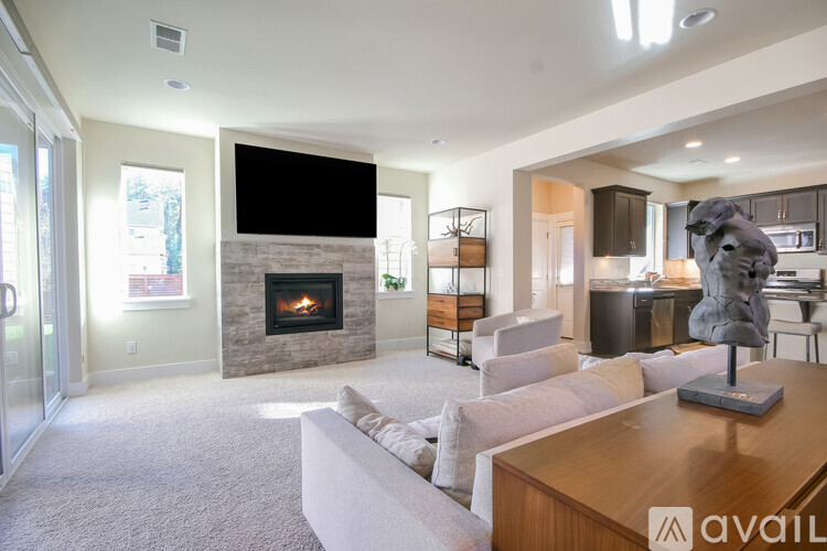 A living room with a fireplace and a television mounted above it.
