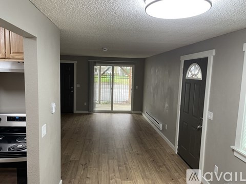 A kitchen with a stove top oven and a wooden floor.