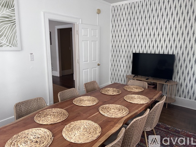 A dining room with a long table and chairs.