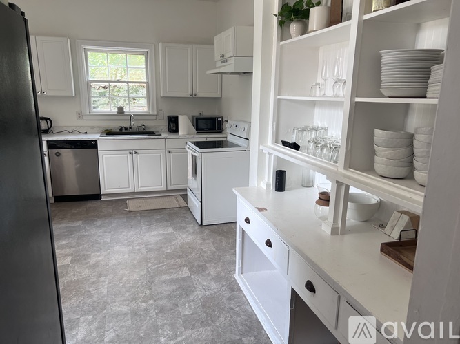 A kitchen with white cabinets and appliances.