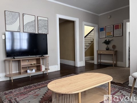 A living room with a wooden table and a television.
