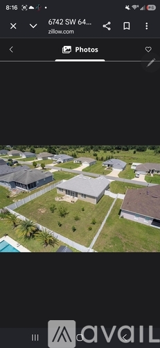 A house with a large front yard and a fence is visible.