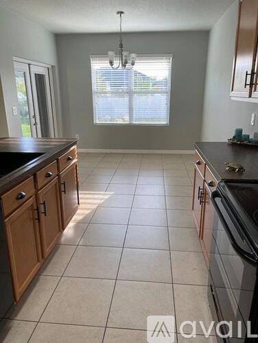 A kitchen with wooden cabinets and black countertops.