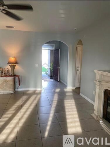 A living room with a fireplace and a lamp on the side table.
