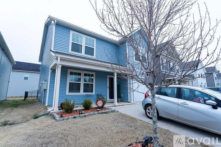 A blue house with a car parked in front.
