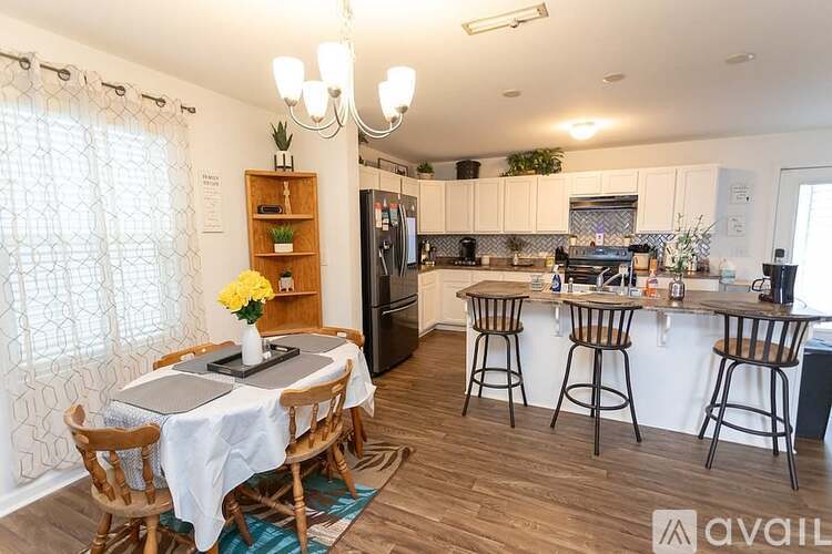 A kitchen with a table and chairs in front of it.