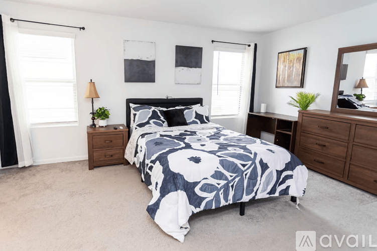 A bedroom with a large bed and a wooden dresser.