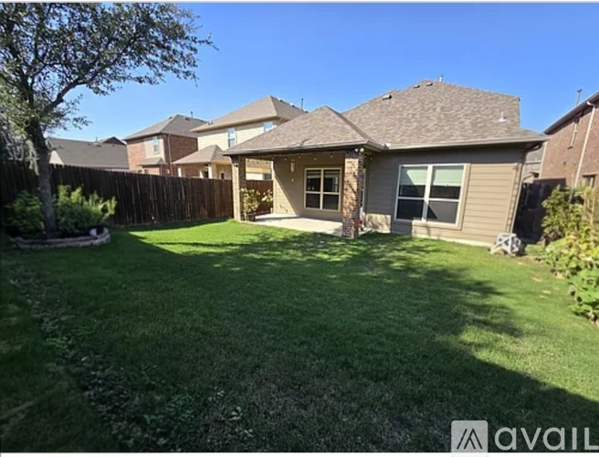 A house with a brown roof and a green lawn in front.