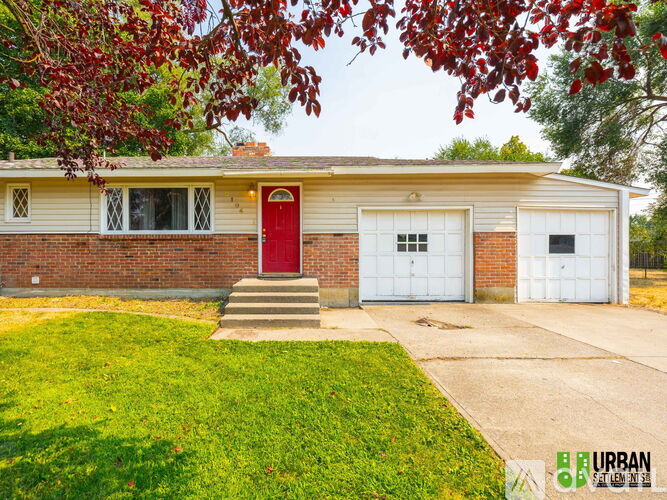 A house with a red door and two white garage doors.