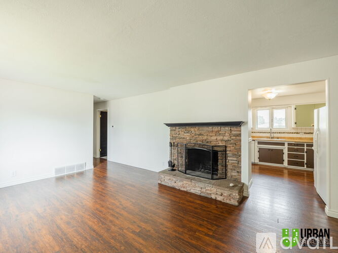 A living room with a fireplace and hardwood floors.